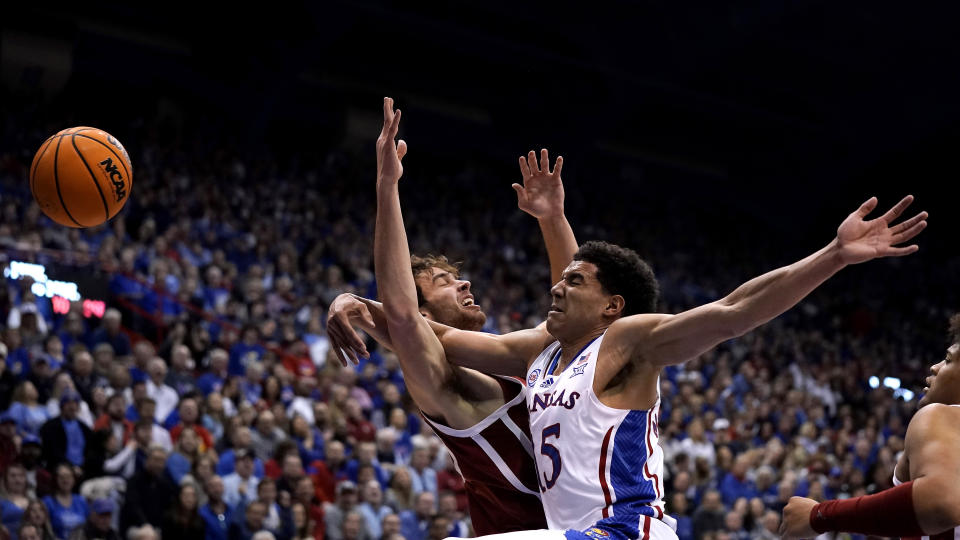 Kansas guard Kevin McCullar Jr., front, and Oklahoma forward Sam Godwin battle for a rebound during the first half of an NCAA college basketball game Tuesday, Jan. 10, 2023, in Lawrence, Kan. (AP Photo/Charlie Riedel)