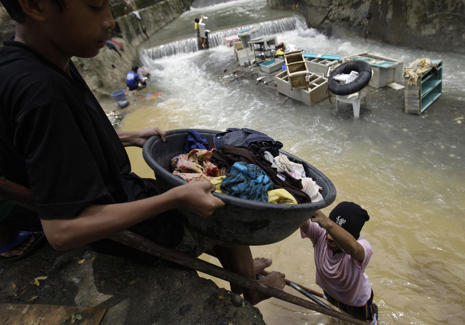 Residents clean their clothes along a river as floods recede in suburban Marikina city, east of Manila, Philippines, Friday Aug. 10, 2012. Philippine disaster officials were shifting Friday from rescue work to a massive clean-up of the capital following nonstop rains that left tons of muck and debris from floods littering the city. (AP Photo/Aaron Favila)