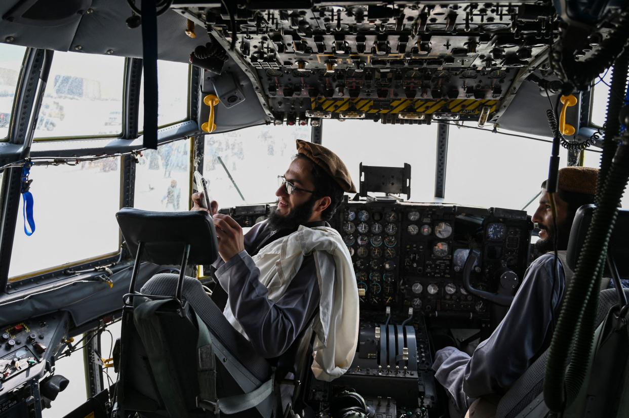 TOPSHOT - Taliban fighters sit in the cockpit of an Afghan Air Force aircraft at the airport in Kabul on August 31, 2021, after the US has pulled all its troops out of the country to end a brutal 20-year war -- one that started and ended with the hardline Islamist in power. (Photo by Wakil KOHSAR / AFP) (Photo by WAKIL KOHSAR/AFP via Getty Images)