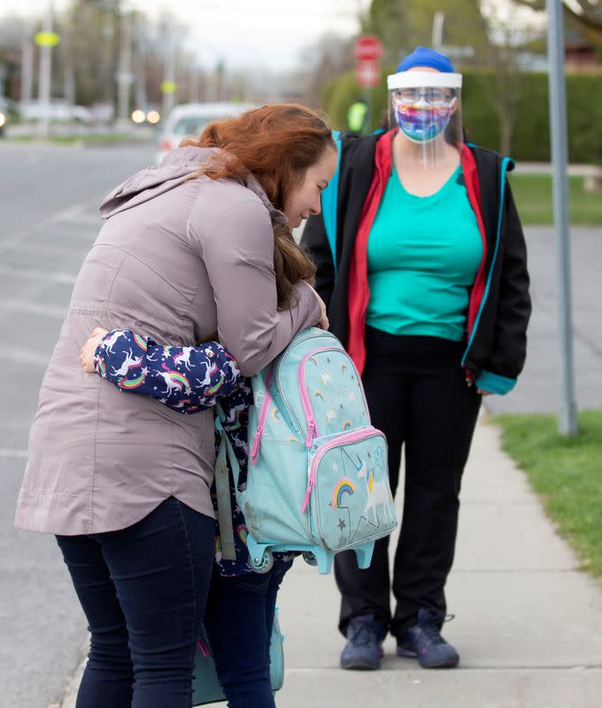 Mother hugs daughter as schools reopen outside the greater Montreal region in Saint-Jean-sur-Richelieu