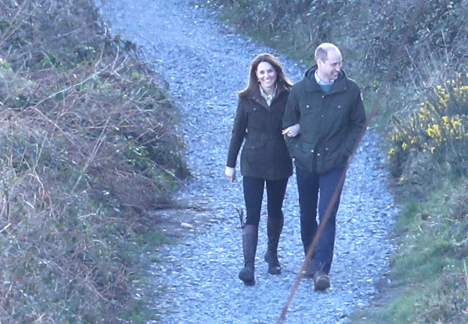 <p>Kate Middleton links her arms in Prince William's as they take a walk to Howth Cliff during their trip to Dublin, Ireland. </p>