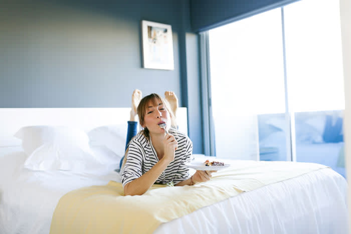 mujer comiendo en la cama