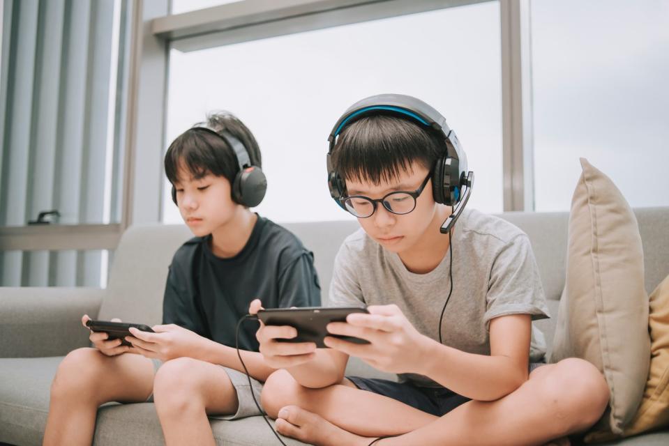 Two people play video games on a couch.