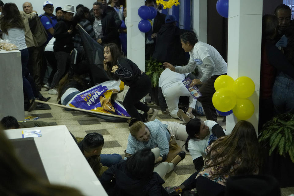 Supporters of presidential candidate Fernando Villavicencio run for cover after he was shot to death while at a campaign rally outside a school in Quito, Ecuador, Wednesday, Aug. 9, 2023. (API via AP)