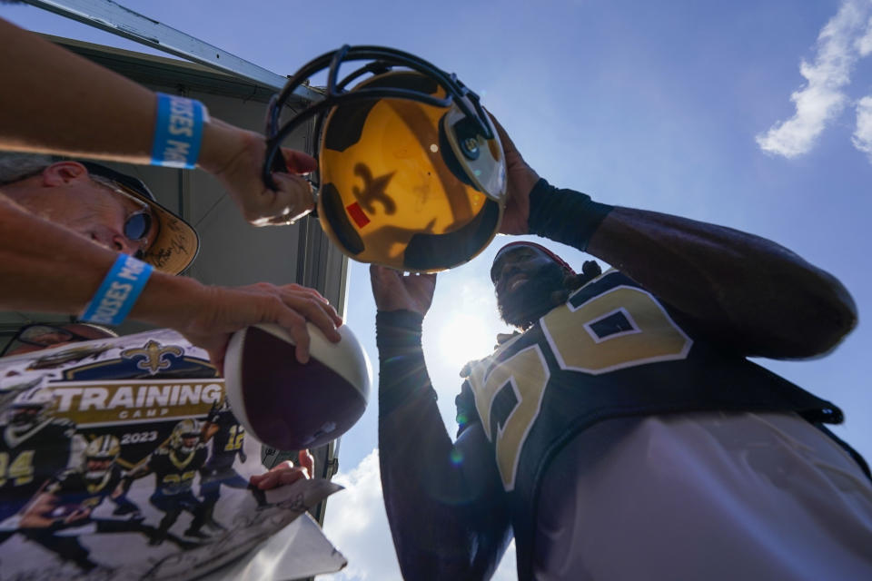 New Orleans Saints linebacker Demario Davis (56) signs autographs for fans during the Back Together Weekend fan appreciation initiative at the NFL team's football training camp in Metairie, La., Saturday, July 29, 2023. (AP Photo/Gerald Herbert)