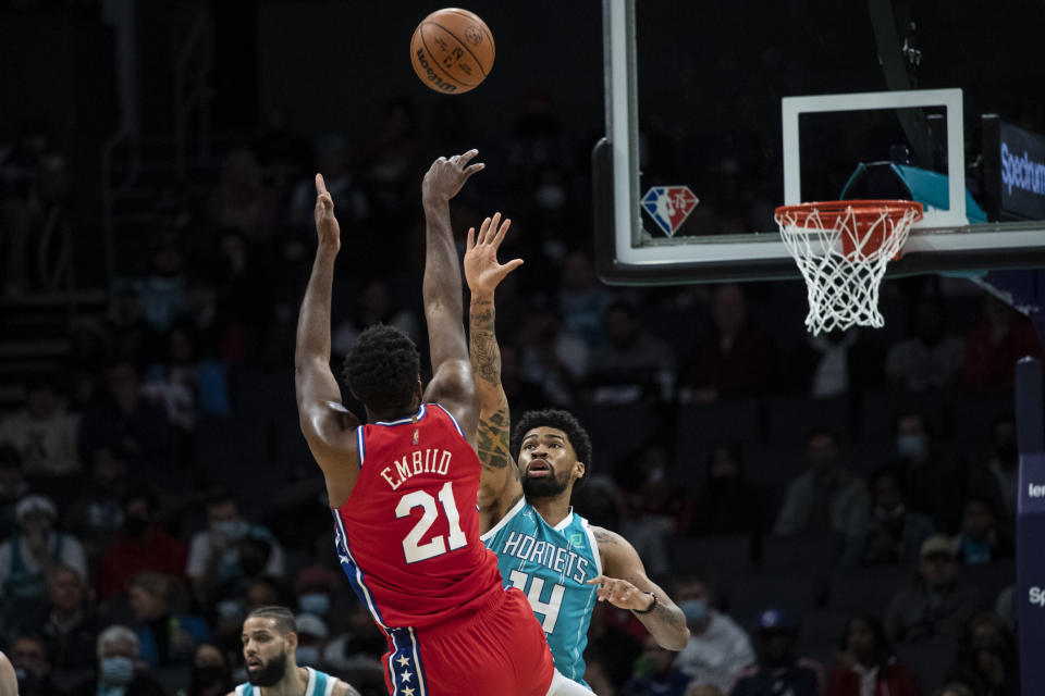 Philadelphia 76ers center Joel Embiid (21) makes a jump shot over Charlotte Hornets center Nick Richards (14) during the first half of an NBA basketball game, Wednesday, Dec. 8, 2021, in Charlotte, N.C. (AP Photo/Matt Kelley)