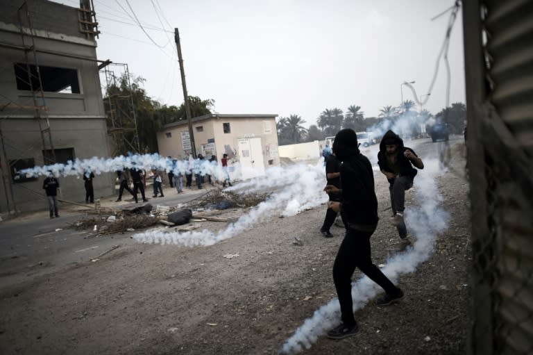 Bahraini protesters taking cover from tear gas during clashes with police following a demonstration in 2015