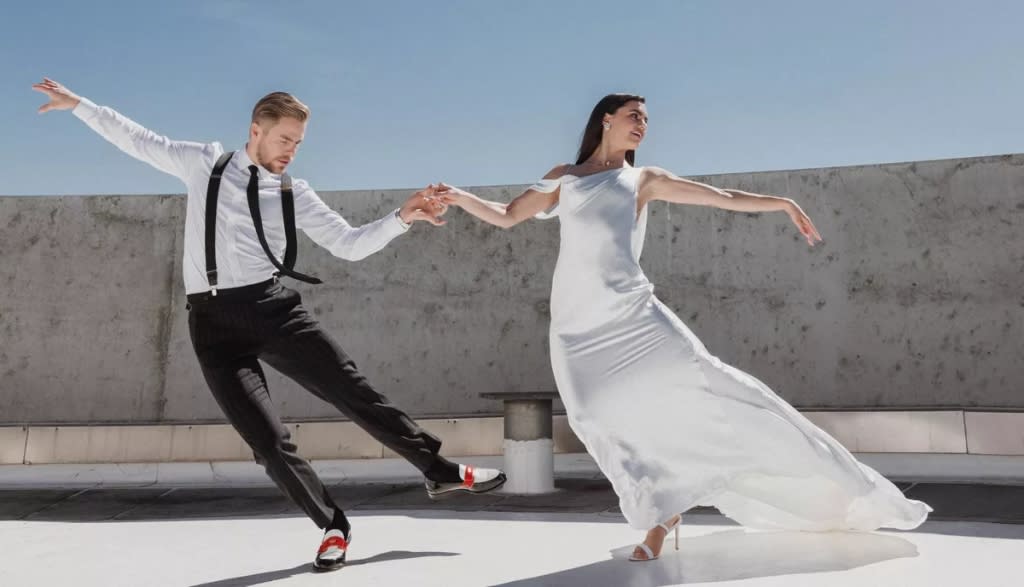 PHOTO BY AMY AND STUART PHOTOGRAPHY © 2023; SUIT BY MUSIKA; DEREK'S SHOES BY CHRISTIAN LOUBOUTIN; WEDDING DRESS BY NEWHITE; HAYLEY'S SHOES BY STUART WEITZMAN; EARRINGS BY MINDY LAM; NECKLACE BY JUSTDESI