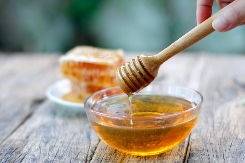 Honey dipper and honeycomb on table