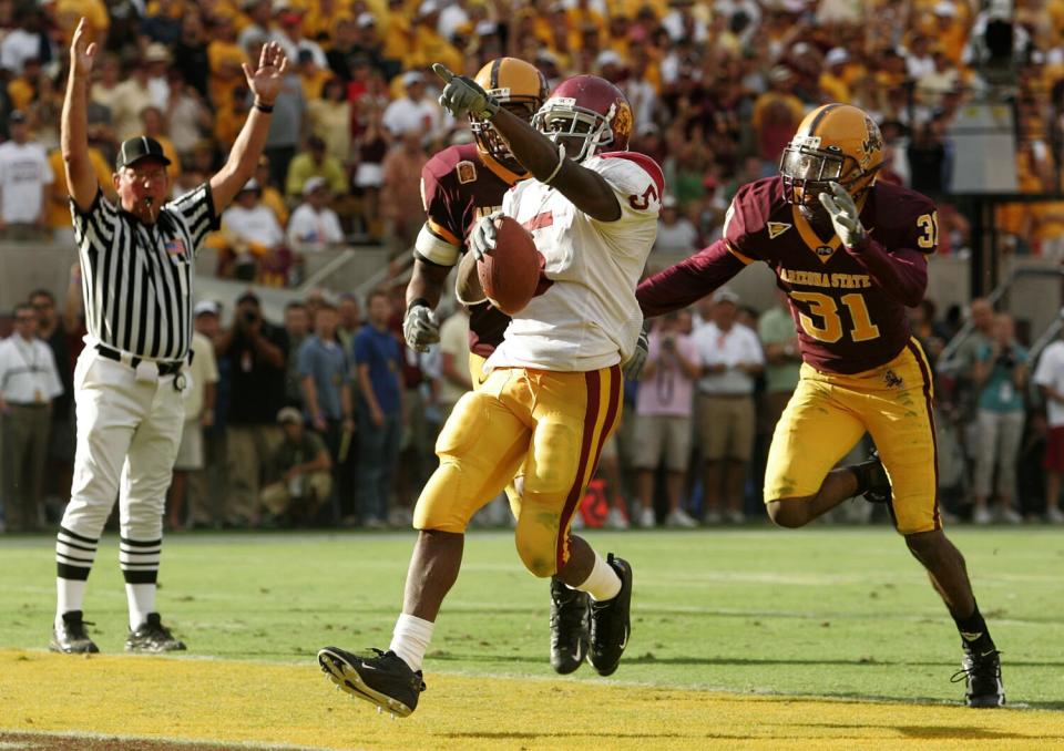 USC running back Reggie Bush scores the go-ahead touchdown as Arizona State's Josh Barrett and Mike Davis Jr. give chase.