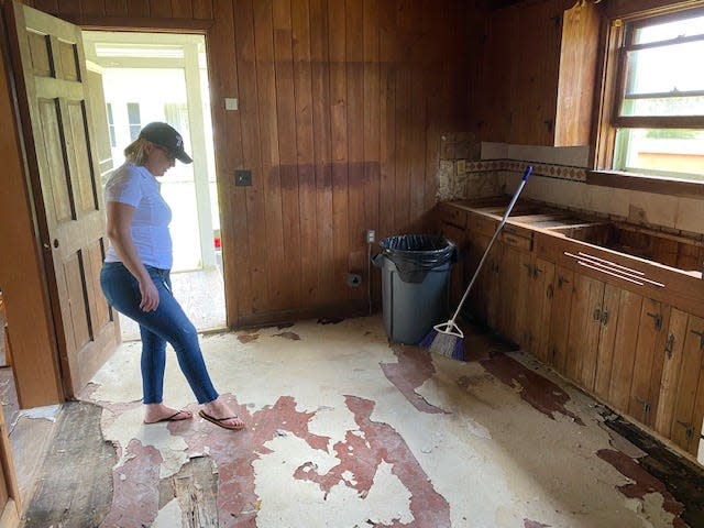 Jennifer Davis, project manager for Port St. Lucie's Community Redevelopment Agency, inspects the flooring in the kitchen at the Peacock Lodge. The lodge will be the future home of the Port St. Lucie Historical Society and a venue for special events.