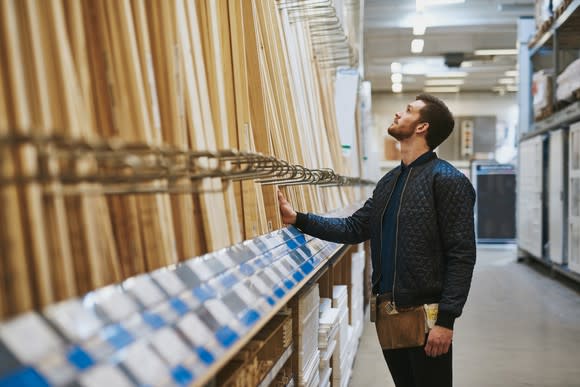 Carpenter looking at boards in home improvement store