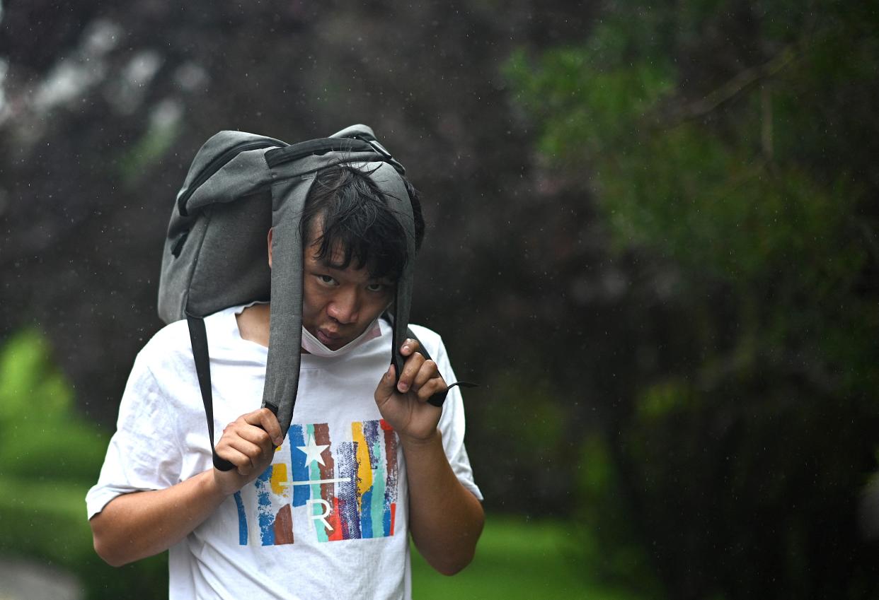 A man uses his bag as cover during a storm in Beijing  (Getty Images)