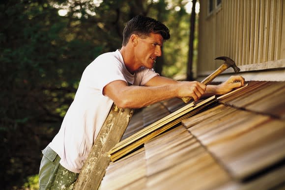 Man hammering in roof shingles