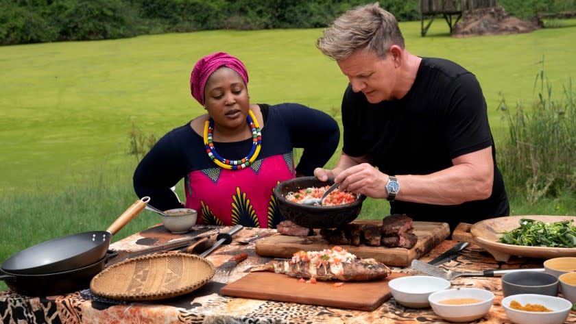 Gordon Ramsay: Uncharted -- National Geographic TV Series, South Africa - Chef Zola Nene (L) observes as Gordon Ramsay tops grilled fish with ushatini, a combination of onions and tomatoes. (National Geographic/Jon Kroll) Chefs Zola Nene and Gordon Ramsay in "Gordon Ramsay: Uncharted" on National Geographic.