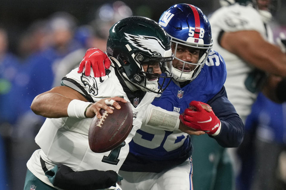 New York Giants linebacker Bobby Okereke (58) puts pressure on Philadelphia Eagles quarterback Jalen Hurts (1) during the second quarter of an NFL football game, Sunday, Jan. 7, 2024, in East Rutherford, N.J. (AP Photo/Seth Wenig)