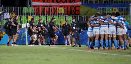 2016 Rio Olympics - Rugby - Men's Placing 5-6 - New Zealand v Argentina - Deodoro Stadium - Rio de Janeiro, Brazil - 11/08/2016. New Zealand players perform the haka as team Argentina huddles. REUTERS/Alessandro Bianchi