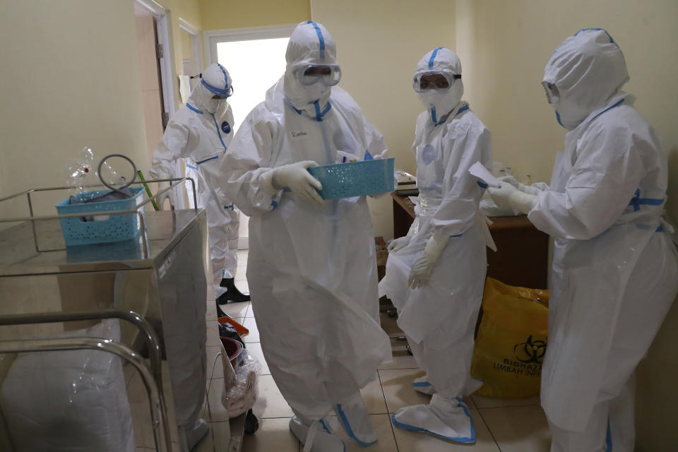 Health workers prepare to treat a COVID-19 patient at the Dr. Suyoto General Hospital in Jakarta, Indonesia, on July 29, 2021. As coronavirus cases skyrocket and deaths climb in Indonesia, health care workers are being depleted as the virus spares nobody. (AP Photo/Tatan Syuflana)