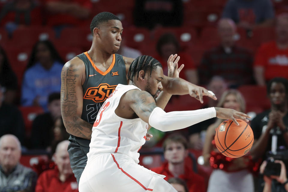 Houston forward J'Wan Roberts, right, attempts to drive around Oklahoma State center Brandon Garrison, left, during the first half of an NCAA college basketball game Tuesday, Feb. 6, 2024, in Houston. (AP Photo/Michael Wyke)