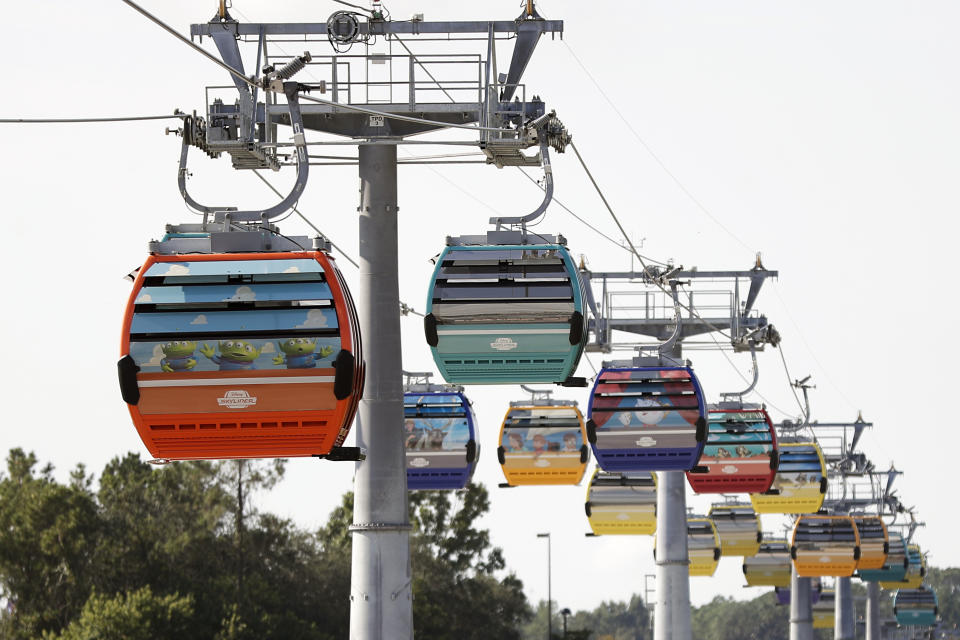 Gondolas move to various locations at Walt Disney World on the Disney Skyliner aerial tram, Friday, Sept. 27, 2019, in Lake Buena Vista, Fla. The Disney Skyliner gondolas opening to visitors on Sunday are the latest addition to one of the largest private transportation systems in the U.S. (AP Photo/John Raoux)