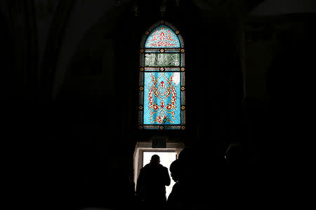 Visitors are silhouetted as they walk below a stained glass window in the Cenacle, a hall revered by Christians as the site of Jesus' Last Supper, in Mount Zion near Jerusalem's Old City January 24, 2019. REUTERS/Ammar Awad