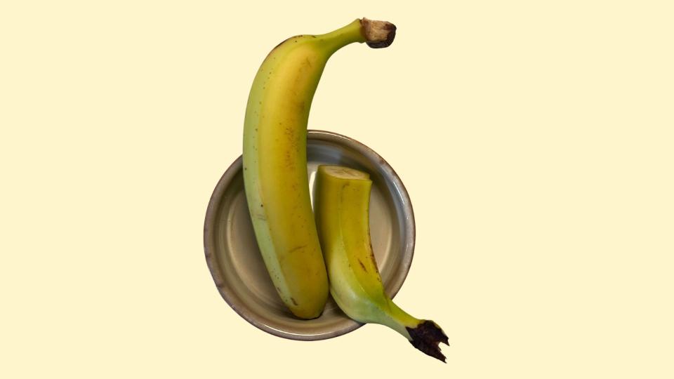 One and a half bananas sitting in a bowl, representing 200 calories