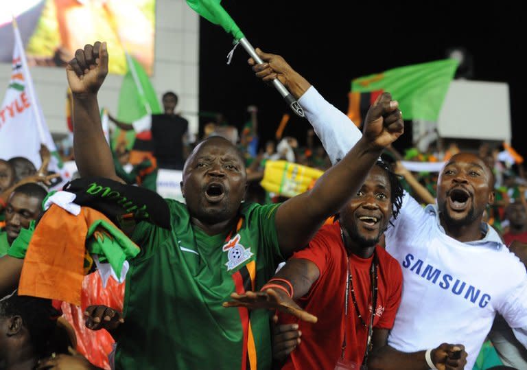 Zambian fans celebrate with the national flag after their team's victory over Ivory Coast in the Africa Cup of Nations (CAN) final match, at stade deI'Amite in Libreville, Gabon, on February 12, 2012. Chipolopolo won the tournament for the first time, just a few kilometres from where a military plane plunged into the sea and claimed the lives of almost all the 1993 Zambian national squad