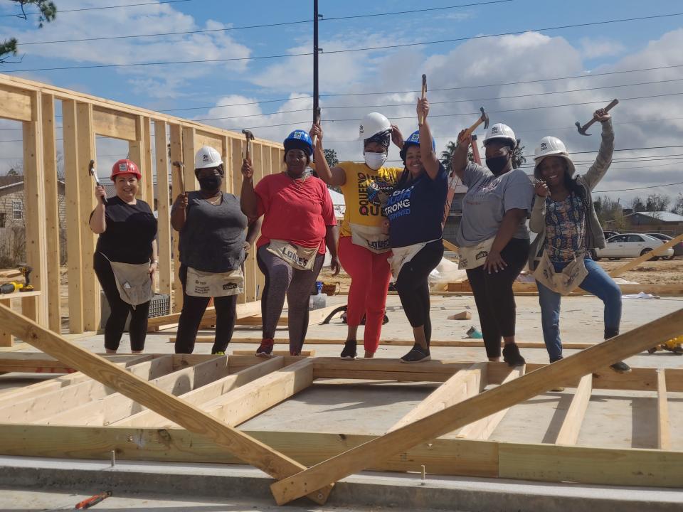 Partner families celebrate while helping frame a Habitat for Humanity home recently.