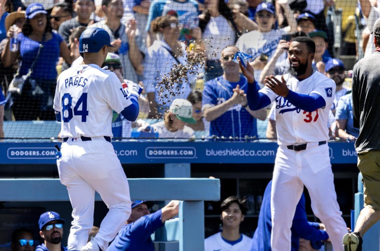 Teoscar Hernandez, right, throws sunflower seeds at Andy Pages after the rookie hit a three-run home run.