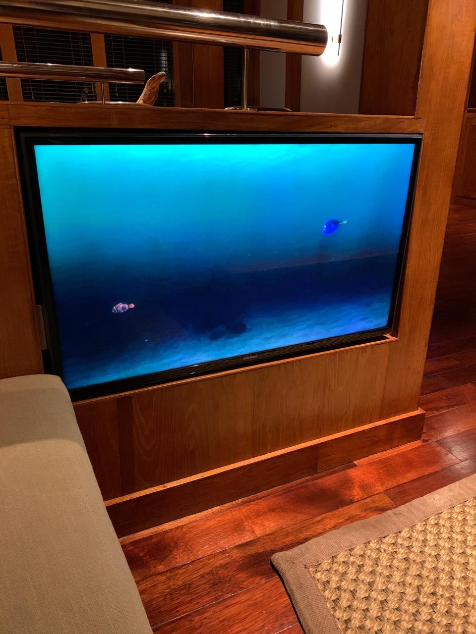 A flatscreen TV with an image of fish swimming on it.