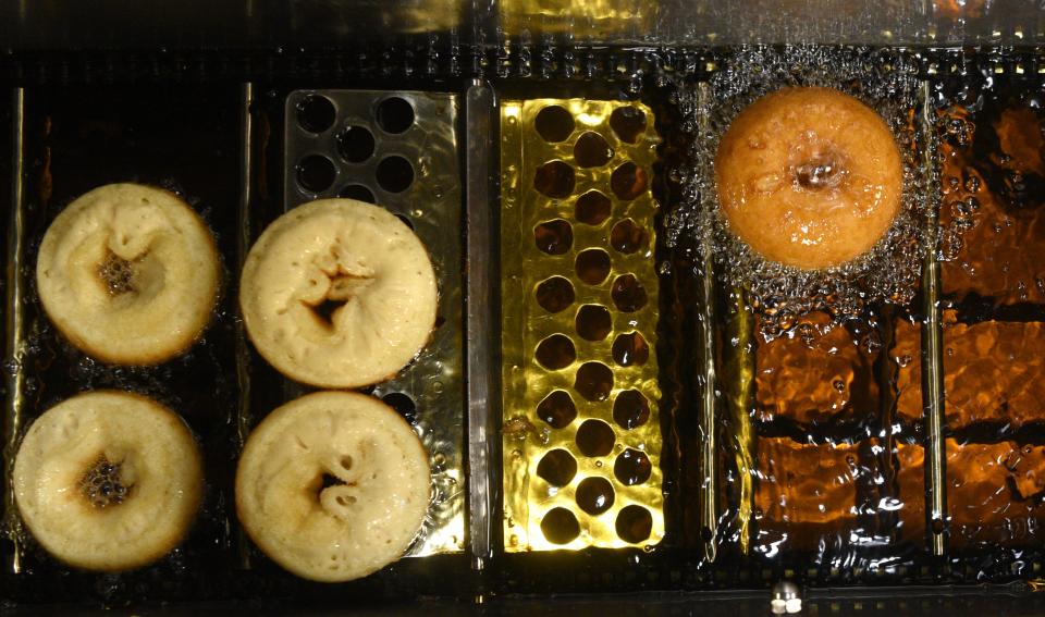 Demarest Farms in Hillsdale makes apple cider donuts daily in three varieties, cinnamon and sugar, plain and powdered sugar. On fall weekends they sell several thousand donuts. Donuts fry and move along a conveyer belt on Wednesday, September 26, 2018.