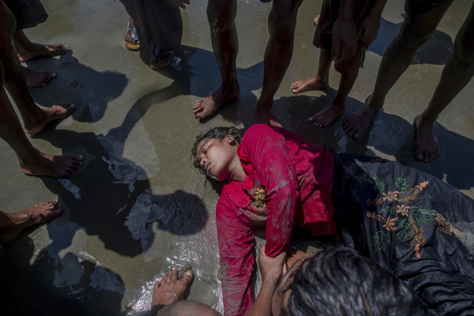 FILE - A Rohingya Muslim woman, who crossed over from Myanmar into Bangladesh, lies unconscious on the shore of the Bay of Bangal after the boat she was traveling in capsized at Shah Porir Dwip, Bangladesh, on Sept. 14, 2017. A dramatic story of survival and rescue off the western coast of Indonesia’s Aceh province has put the spotlight again on the plight of ethnic Rohingya Muslim refugees from Myanmar who make extremely dangerous voyages across the Indian Ocean to seek better lives. (AP Photo/Dar Yasin, File)
