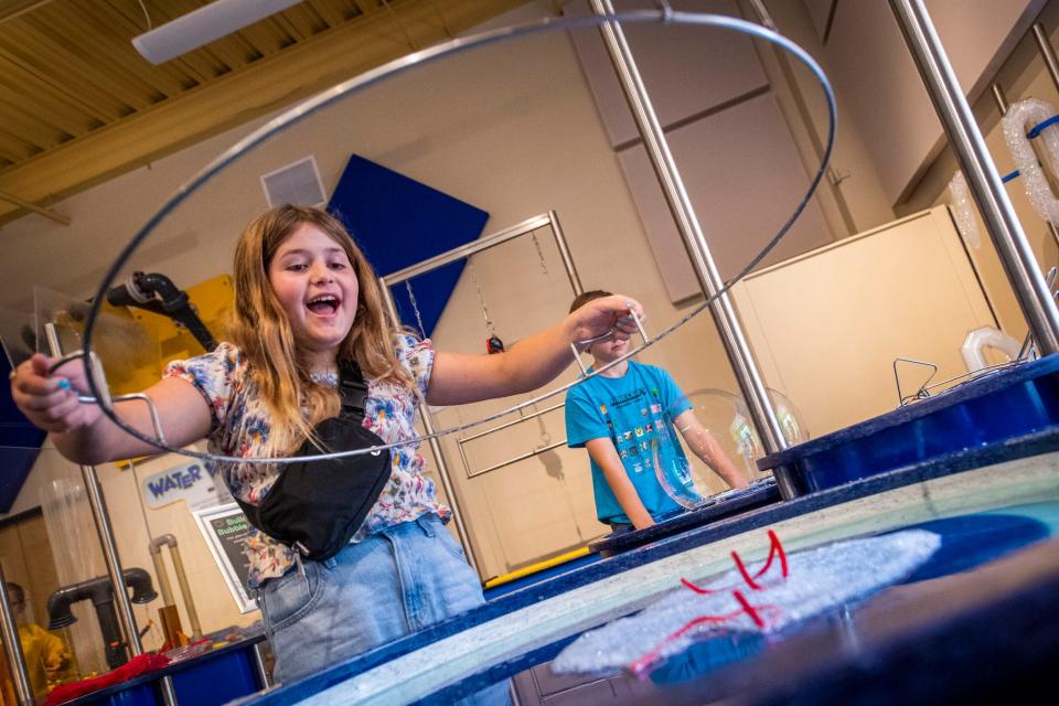 Nora Armie smiles as her large bubble pops during BubbleFest at WonderLab Science Museum on Saturday, June 17, 2023.