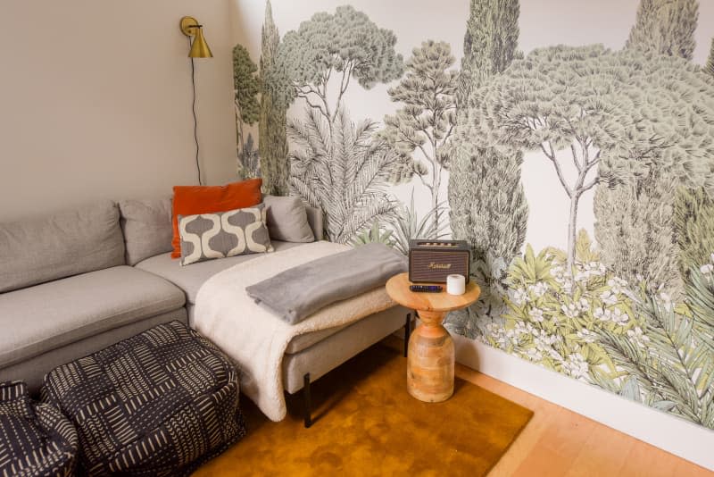 Woodland wallpaper mural in living room of shared home.