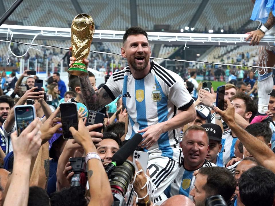 Messi holds the trophy on the pitch after Argentina’s win (PA)
