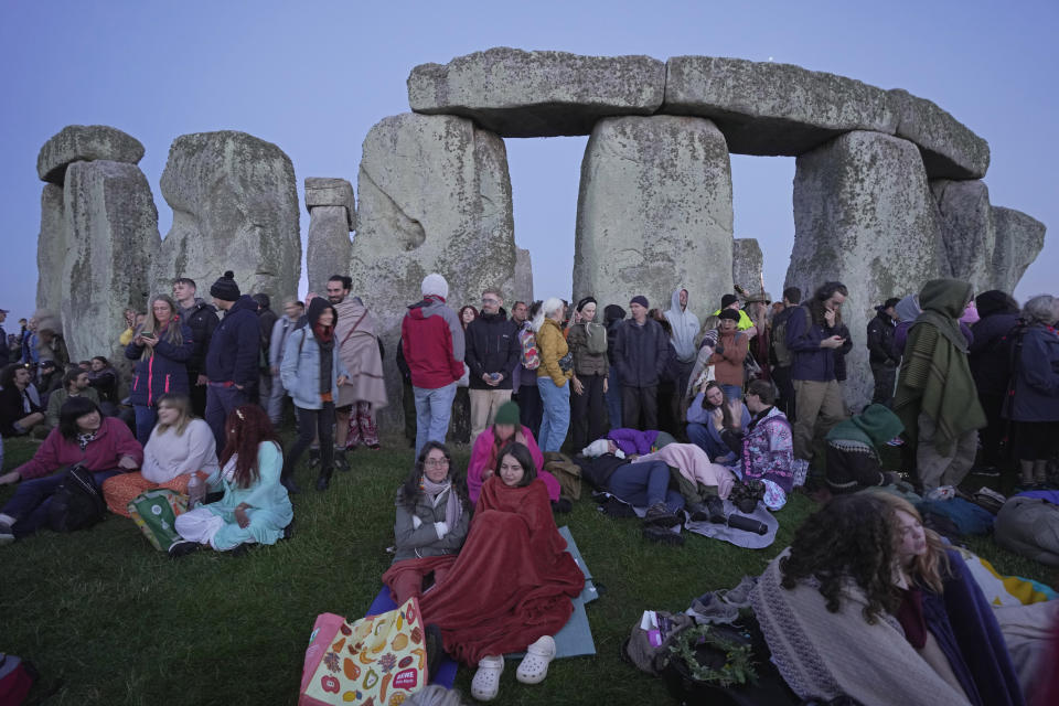 Revelers wait for sunrise as they gather at the ancient stone circle Stonehenge to celebrate the Summer Solstice, the longest day of the year, near Salisbury, England, Wednesday, June 21, 2023. (AP Photo/Kin Cheung)