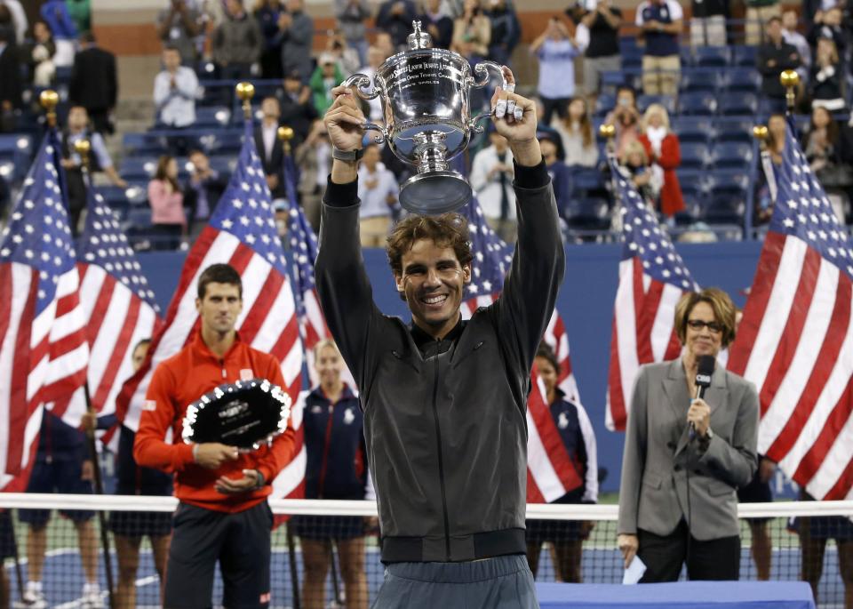 Rafael Nadal of Spain raises his trophy after defeating Novak Djokovic of Serbia (L) in their men's final match at the U.S. Open tennis championships in New York, September 9, 2013. REUTERS/Mike Segar (UNITED STATES - Tags: SPORT TENNIS)