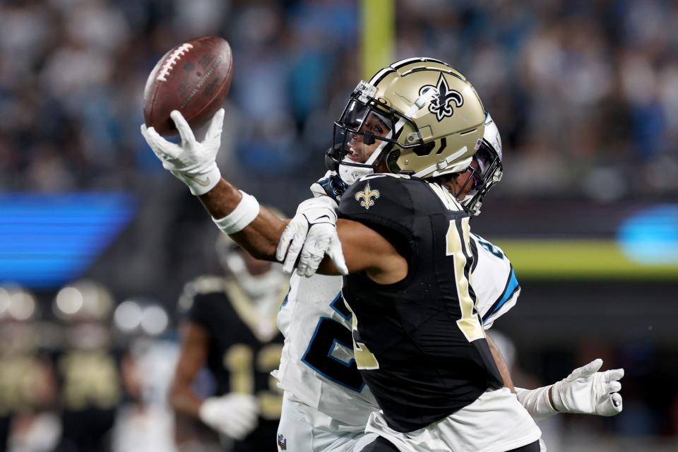 CHARLOTTE, NORTH CAROLINA - SEPTEMBER 18: Chris Olave #12 of the New Orleans Saints bobbles and catches a 42 yard pass against CJ Henderson #23 of the Carolina Panthers during the third quarter in the game at Bank of America Stadium on September 18, 2023 in Charlotte, North Carolina. (Photo by Jared C. Tilton/Getty Images)