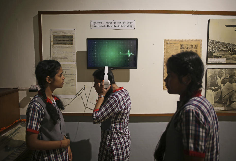 A schoolgirl listens to the recreated heartbeat of India's independence leader Mahatma Gandhi at Gandhi museum on the eve of his 150th birth anniversary in New Delhi, India, Tuesday, Oct. 1, 2019. India’s biggest political parties are vying for the political legacy of iconic independence leader Mahatma Gandhi on the 150th anniversary of his birth. (AP Photo/Altaf Qadri)