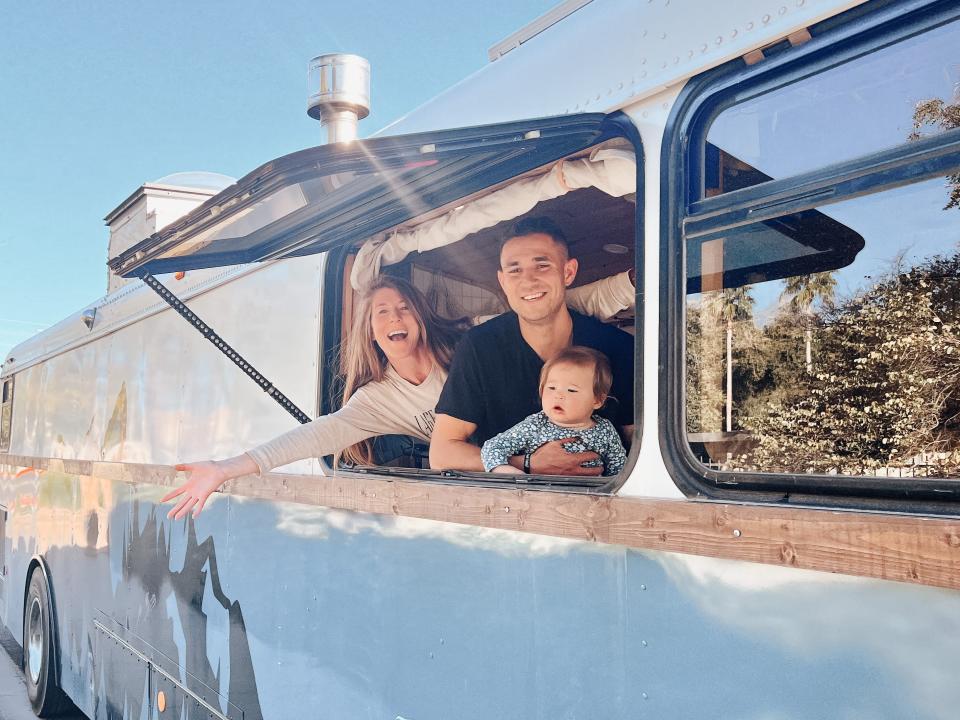 kristin reid and her family looking out the window of their converted school bus