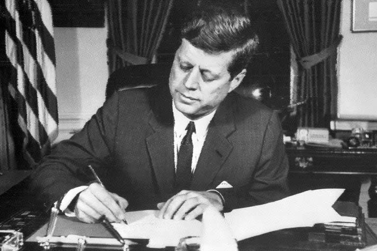 En esta foto de archivo tomada el 24 de octubre de 1962, el presidente estadounidense John Fitzgerald Kennedy firma la orden de bloqueo naval de Cuba, en la Casa Blanca