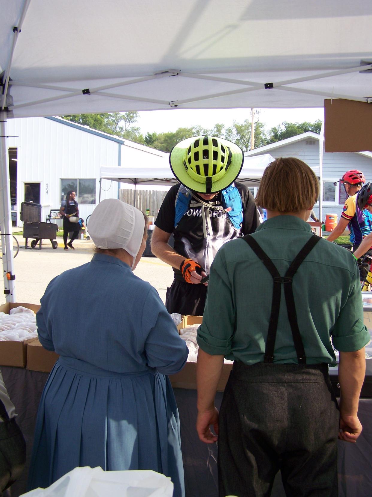 Katie Gingrich and her son Perry serve-up a fried pie to a RAGBRAI rider in Milo on Wednesday, July 24, 2024.