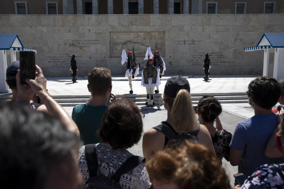 People watch a change of shift of Presidential guards, in Athens, Sunday, May 23, 2021. Greece launched its tourism season last week amid a competitive scramble across the Mediterranean to lure vacationers emerging from lockdowns. (AP Photo/Yorgos Karahalis)