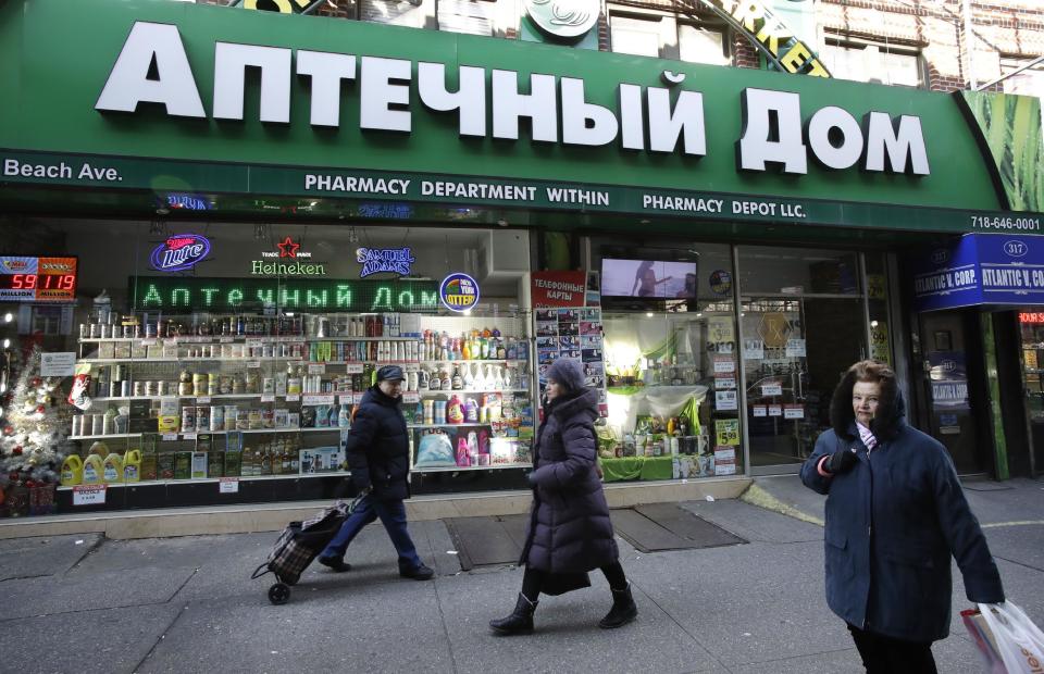 In this Dec. 16, 2016 photo, people walk past a Brighton Beach pharmacy that caters to the Russian community in the Brooklyn borough of New York. Most Russian-speaking expatriates interviewed by The Associated Press this past week in New York City’s heavily Russian enclaves shrug off accusations that Kremlin hacking helped sway the presidential election to Donald Trump. They portray it as nothing more than political sour grapes. (AP Photo/Mark Lennihan)