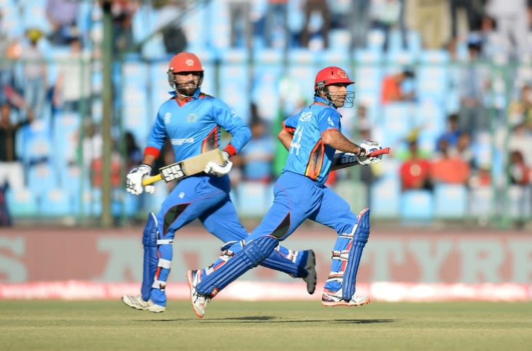 Afghanistan batsman Noor Ali (L) runs between the wickets with captain Asghar Stanikzai during the World T20 match against England at The Feroz Shah Kolta Cricket Stadium in New Delhi on March 23, 2016