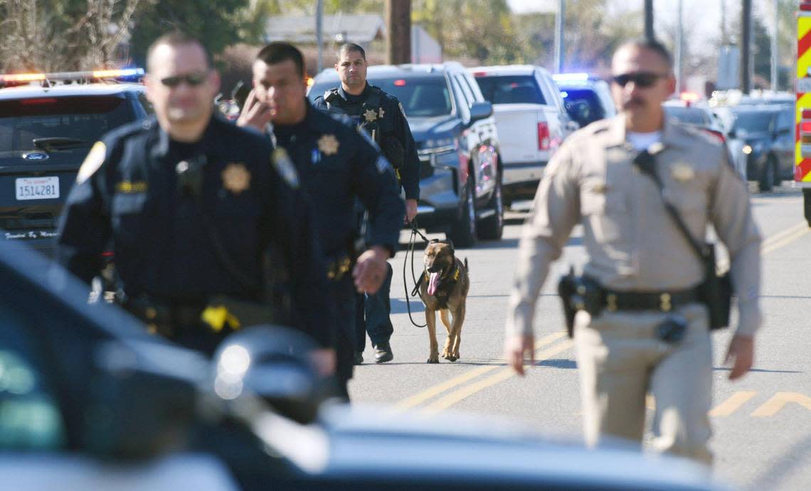 Selma Police and CHP officers walk east along Rose Avenue just west of 99 after a shooting incident Tuesday, Jan. 31, 2023 in Selma.