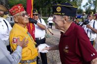 Navajo Code Talker Thomas Begay, left, shakes hands with Ron Enderle, right, a U.S. Marine veteran from the Korean War era, at the Arizona State Navajo Code Talkers Day ceremony, Sunday, Aug. 14, 2022, in Phoenix. Begay is one of three remaining Navajo Code Talkers that are still alive. (AP Photo/Ross D. Franklin)