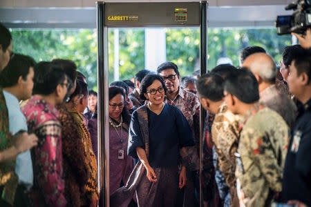 Indonesian Finance Minister Sri Mulyani Indrawati (C) walks through a metal detector gate upon arrival at the Finance Minister's office in Jakarta, Indonesia, July 27, 2016. Antara Foto/M Agung Rajasa/via REUTERS