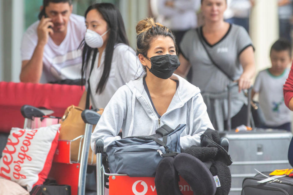 Passengers arriving at Sydney Airport wearing face masks. Source: Getty