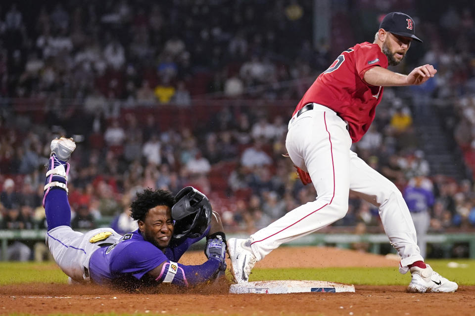 Colorado Rockies' Jurickson Profar, left, is put out by Boston Red Sox relief pitcher Chris Martin, right, while trying to reach first during the ninth inning of a baseball game at Fenway Park, Tuesday, June 13, 2023, in Boston. (AP Photo/Charles Krupa)